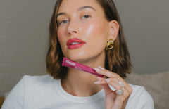 Hailey Bieber applying Peptide Lip Tint on lips.