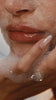 A close up of Hailey Bieber's face, covered in foam