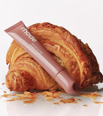 Toast lip tint next to a croissant