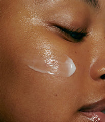 model with swatch of peptide glazing fluid on cheek