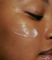 model with swatch of peptide glazing fluid on cheek