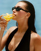HB holding a martini glass with lemon twist and peptide lip tint in lemontini