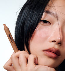 model holding peptide lip shape, wearing shade lunge