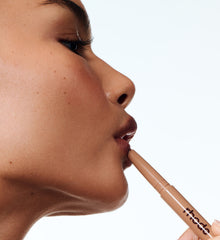 model applying peptide lip shape on lips