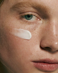 model with swatch of barrier restore cream on cheekbone