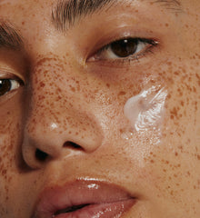 model with peptide glazing fluid swatch on cheek