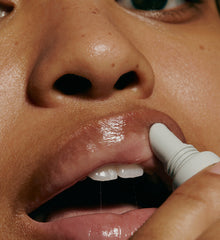 model applying peptide lip treatment (close up)