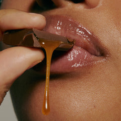 model biting into caramel (close up), wearing peptide lip treatment