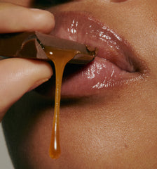 model biting into caramel (close up), wearing peptide lip treatment