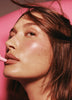 Hailey Bieber applying peptide lip tint in jelly bean