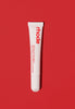 peptide lip treatment in strawberry glaze, against a red background