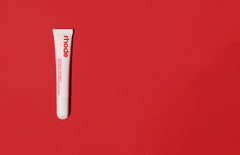 peptide lip treatment in strawberry glaze, against a red background