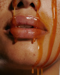 model wearing peptide lip treatment, with caramel dripping on face