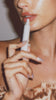 Hailey Bieber applying peptide lip treatment on lips