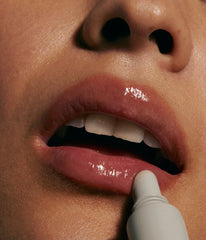 model applying peptide lip treatment (close up)