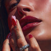 Hailey Bieber with glossy lips, applying peptide lip treatment in strawberry glaze