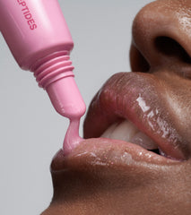 close up of model's lips, applying peptide lip tint in jelly bean