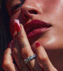 Hailey Bieber with glossy lips, applying peptide lip treatment in strawberry glaze