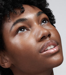 model with glazed skin and glossy lips, wearing peptide lip tint in jelly bean