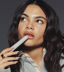 Ariana Greenblatt with glossy lips holding the peptide lip treatment