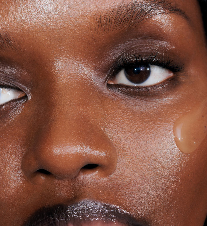 a close up of a model's skin with a swatch of pineapple refresh on her face