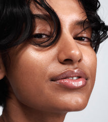 model with shimmery, glossy lips - wears peptide lip tint in jelly bean