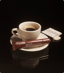 peptide lip tint in shade espresso next to a cup of espresso