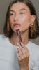 Hailey wears peptide lip tint in shade espresso