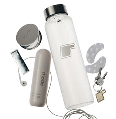 glazing mist with the rhode mirror and eye patches next to rhode water bottle, rhode keychain and gum