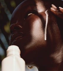 Model applying glazing milk on skin