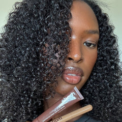 Model holding Peptide Lip Tint in Espresso + Peptide Lip Shape