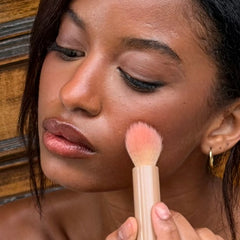 applying pocket blush on cheeks with pocket brush
