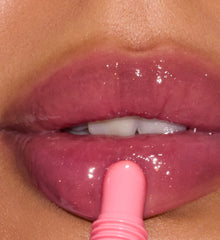 Close-up of a person applying sweet pea lip tint to their lips.