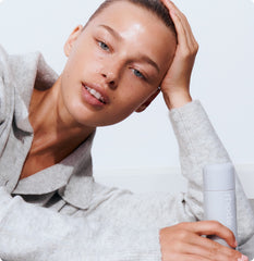 Model holding a bottle of Glazing Milk