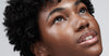 model with glazed skin and glossy lips, wearing peptide lip tint in jelly bean