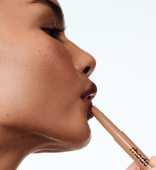 model applying peptide lip shape on lips