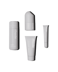 flat lay of all 4 rhode kit products: glazing milk, peptide glazing fluid, barrier restore cream, unscented peptide lip treatment