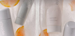 rhode skincare products in ice with orange slices