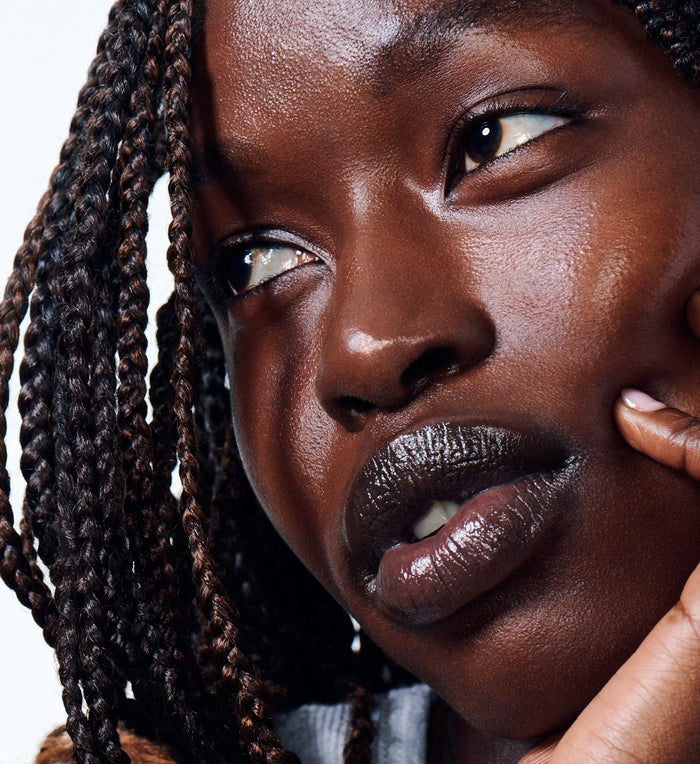 model wearing peptide lip treatment in strawberry glaze