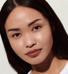 model with glossy lips, wearing toast lip tint