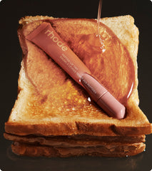 peptide lip tint in shade toast on top of a pile of toast