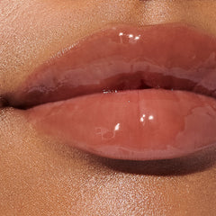 model with glossy lips, wearing toast lip tint