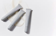 three rhode peptide lip treatment with product swatches in the background