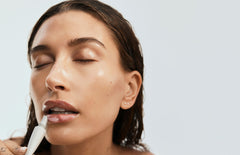 Hailey Bieber applying rhode peptide lip treatment on lips